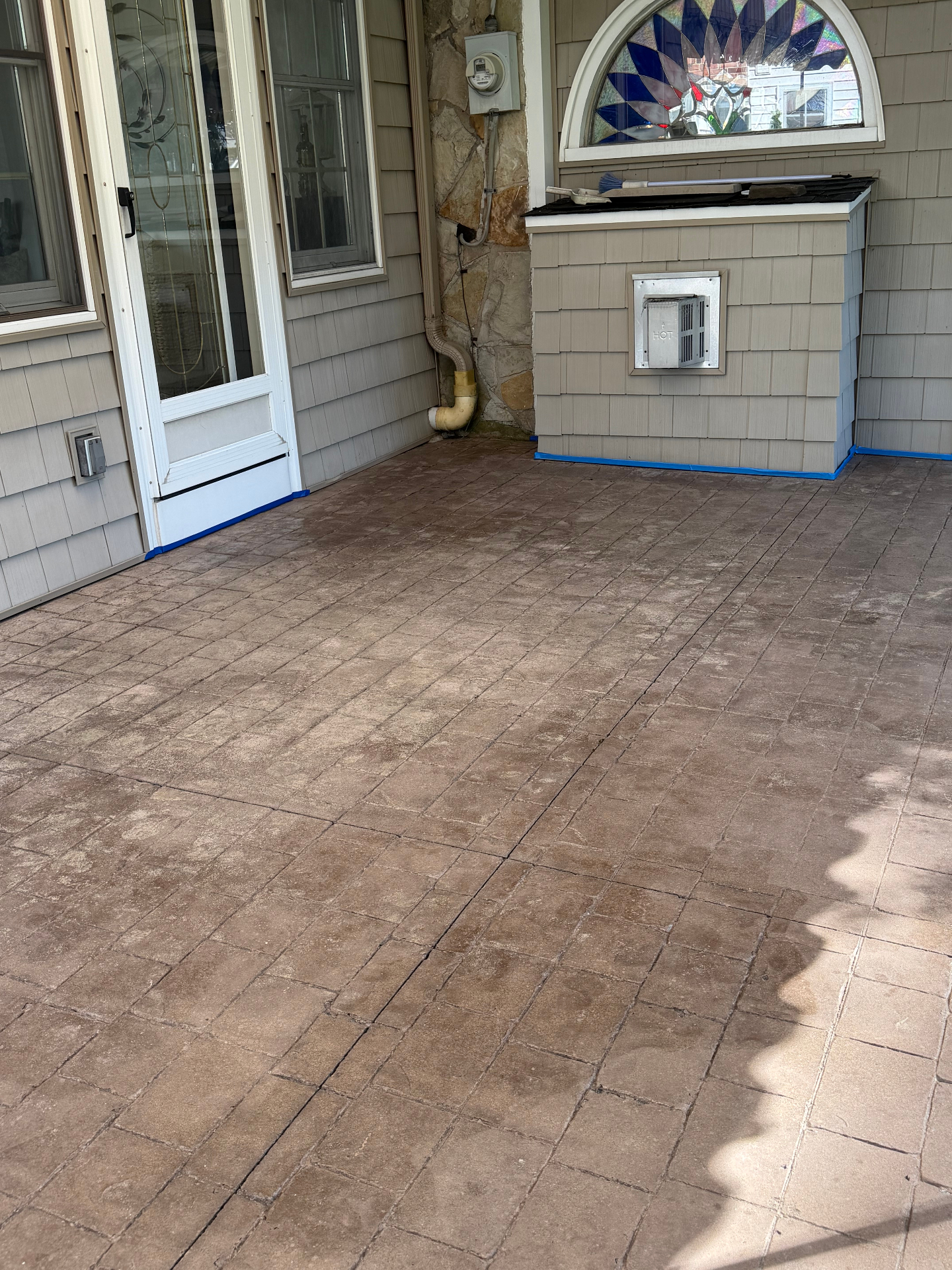 Before — stamped concrete covered porch washed, re-colored and sealed