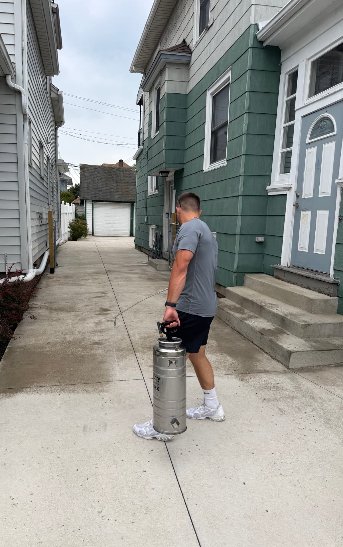 Cornwell Property Services applying concrete sealer to a residential driveway in Western New York